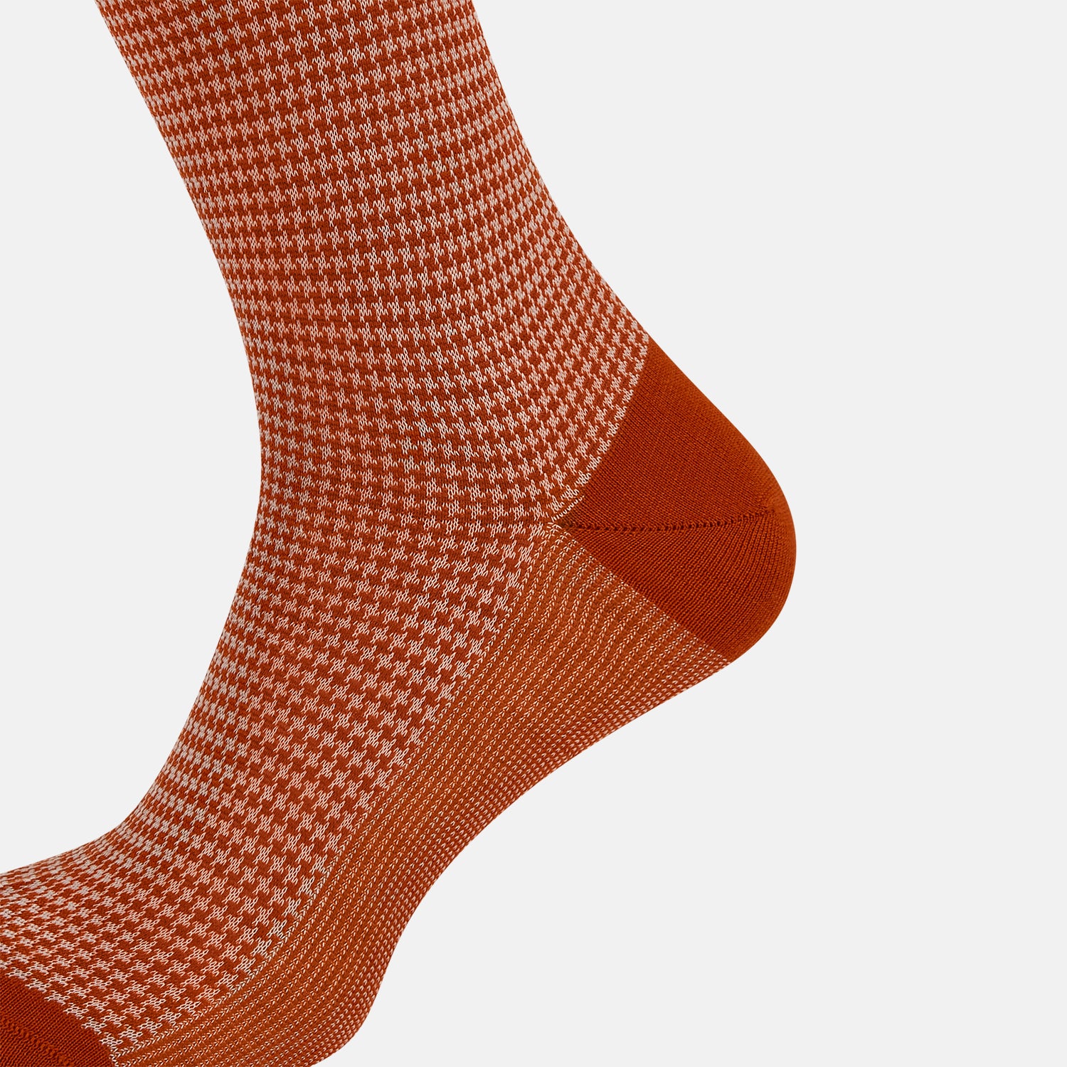 View 4 of product The Turnbull & Asser SOCKS LONG COTTON HOUNDSTOOTH ROSE is a single over-the-calf sock in rusty orange with a white houndstooth pattern and solid orange toe, heel, and cuff, shown on a plain white background.
