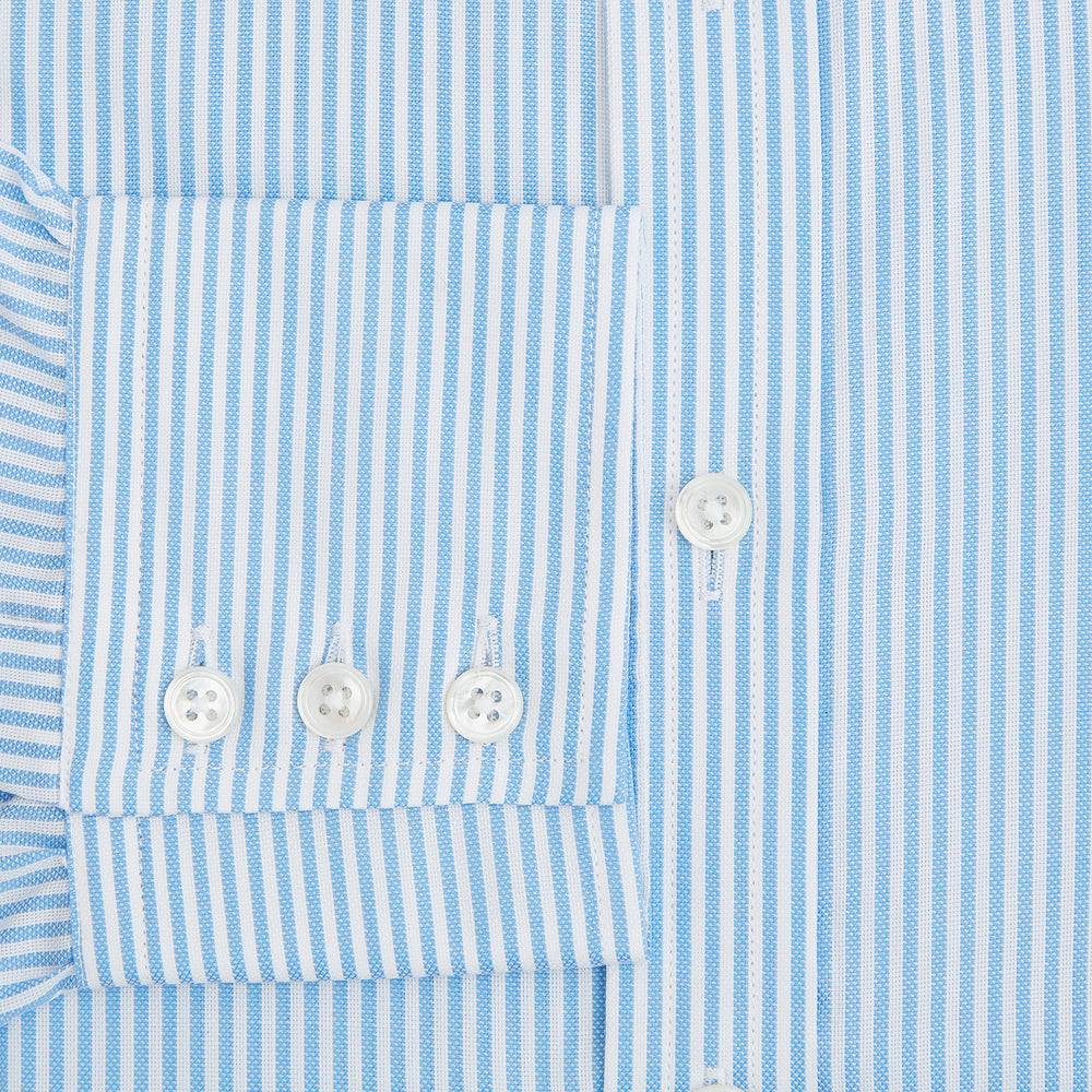 The Turnbull & Asser Blue Bengal Stripe Mayfair Shirt features light blue and white vertical stripes, a classic T&A collar, white buttons, and buttoned cuffs. Laid flat on a white background.