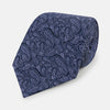 View 1 of product The Turnbull & Asser Navy Paisley Printed Silk Tie, featuring an intricate light lavender paisley design, is shown rolled up on a plain white background.