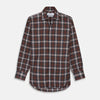 View 2 of product Close-up of Turnbull & Asser's Rust Check Cotton Fabric, featuring intersecting brown, black, and white stripes in a plaid pattern, displayed within a circular frame on a plain light gray background.
