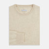 View 4 of product The Turnbull & Asser Cream Cashmere Round Neck Jumper features long sleeves, ribbed cuffs, and a ribbed hem—a versatile men’s knitwear staple, shown against a white background.