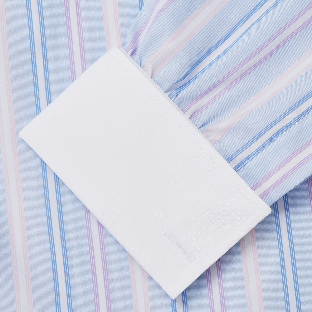 The Turnbull & Asser Light Blue Multi Stripe Cotton Regular Fit Penrose Shirt features light blue, white, and pink stripes with a crisp white collar and cuffs, displayed on a white background.