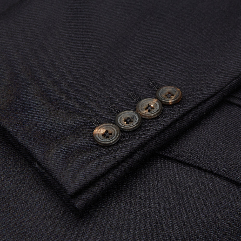 The Turnbull & Asser Navy Escorial Wool Jacket is a tailored men's blazer featuring notch lapels, a single-breasted one-button front, and multiple pockets, shown flat against a white background.