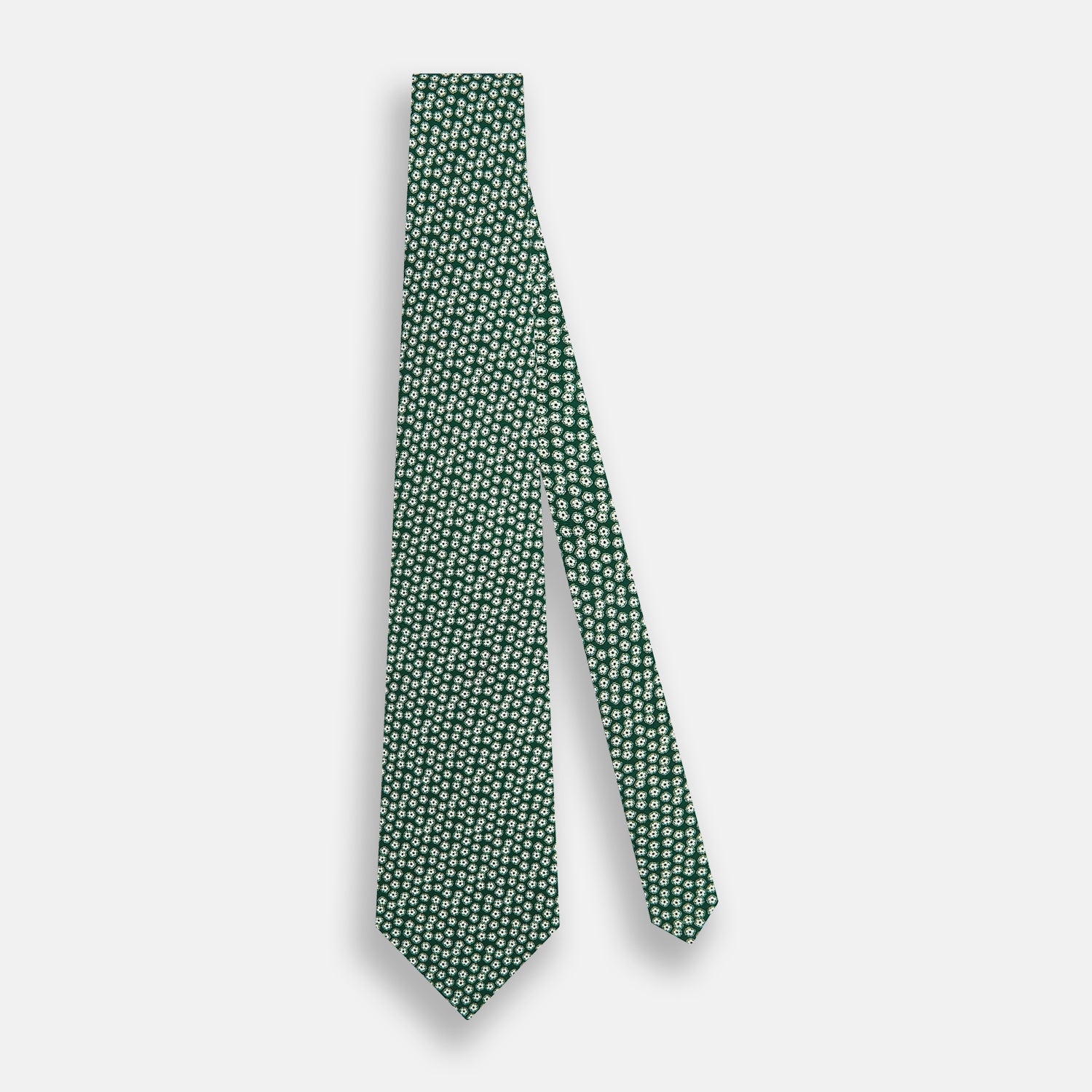 View 2 of product The Turnbull & Asser Forest Green Flower Patterned Silk Tie, crafted from fine English silk, features a repeating white floral design and is shown rolled up on a white background.
