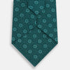 View 3 of product The Forest Green Medallion Printed Silk Tie by Turnbull & Asser features a repeating medallion pattern in lighter green tones, crafted from English silk and shown rolled up on a plain white background.