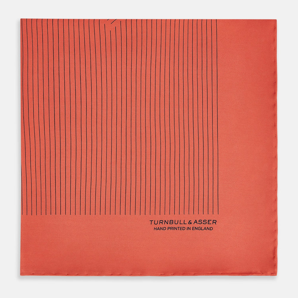 The Orange Stripe Silk Pocket Square by Turnbull & Asser features thin black vertical lines and "TURNBULL & ASSER HAND PRINTED IN ENGLAND" in the corner, neatly folded on a white background.