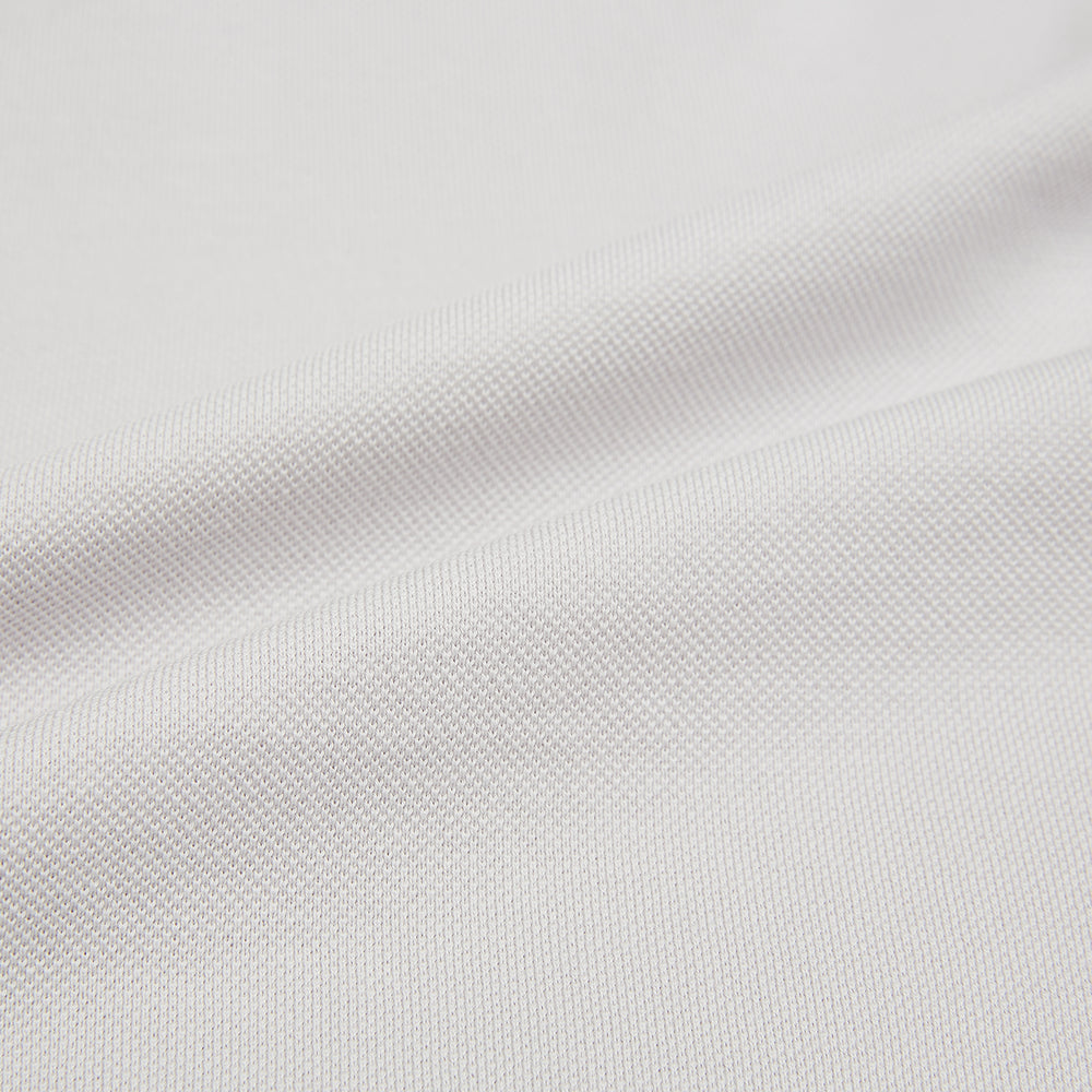 The Turnbull & Asser Pale Pink Polo Shirt is a cotton jersey short-sleeve polo with a collar, three brown buttons on the placket, and a button-flap chest pocket, shown against a white background.