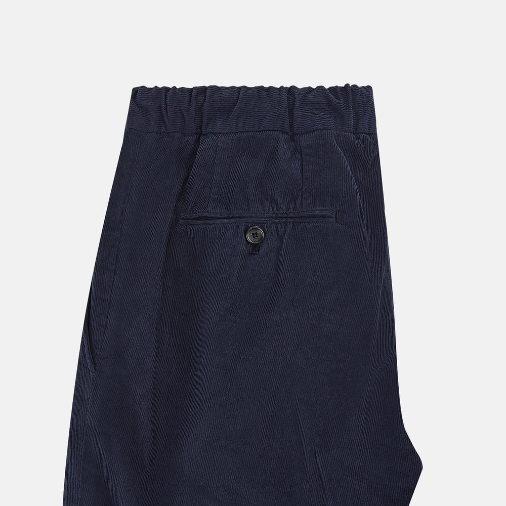 Turnbull & Asser's Light Navy Corduroy Miles Trousers feature a straight-leg stretch fit, elasticated waist, and matching fabric drawstring, shown on a plain white background.