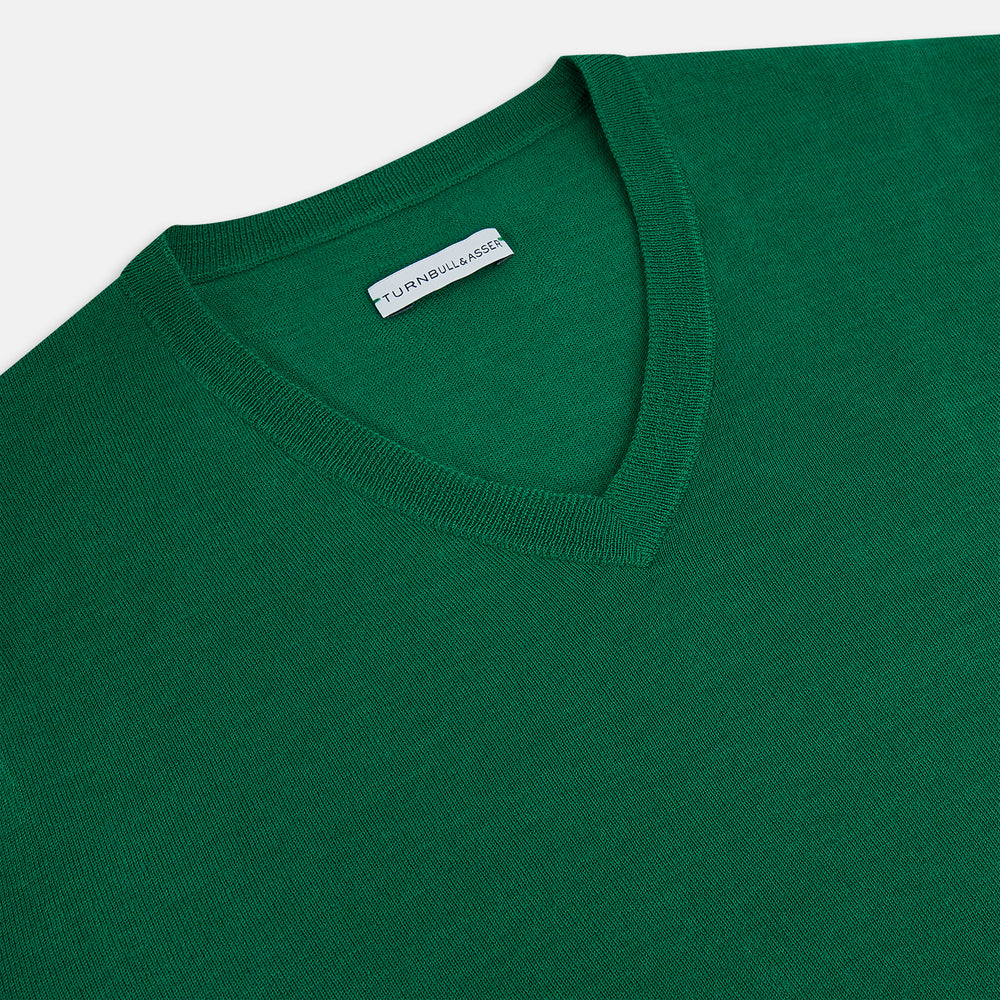The Turnbull & Asser Hunter Green Fine Merino V-Neck Jumper is displayed against a white background, highlighting classic knitwear style.