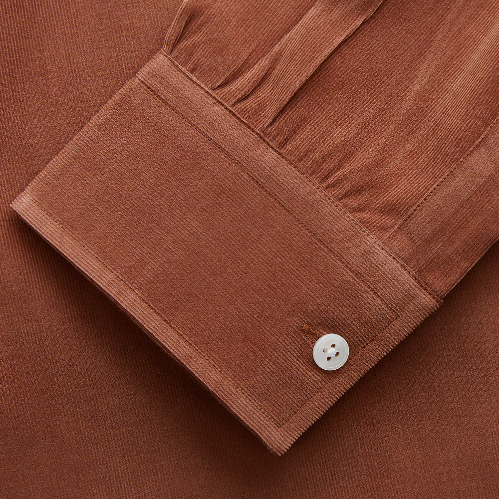The Turnbull & Asser Rust Cotton Weekend Fit Blake Shirt features long sleeves, a stand collar, and white buttons—an ideal casual piece displayed flat on a white background.