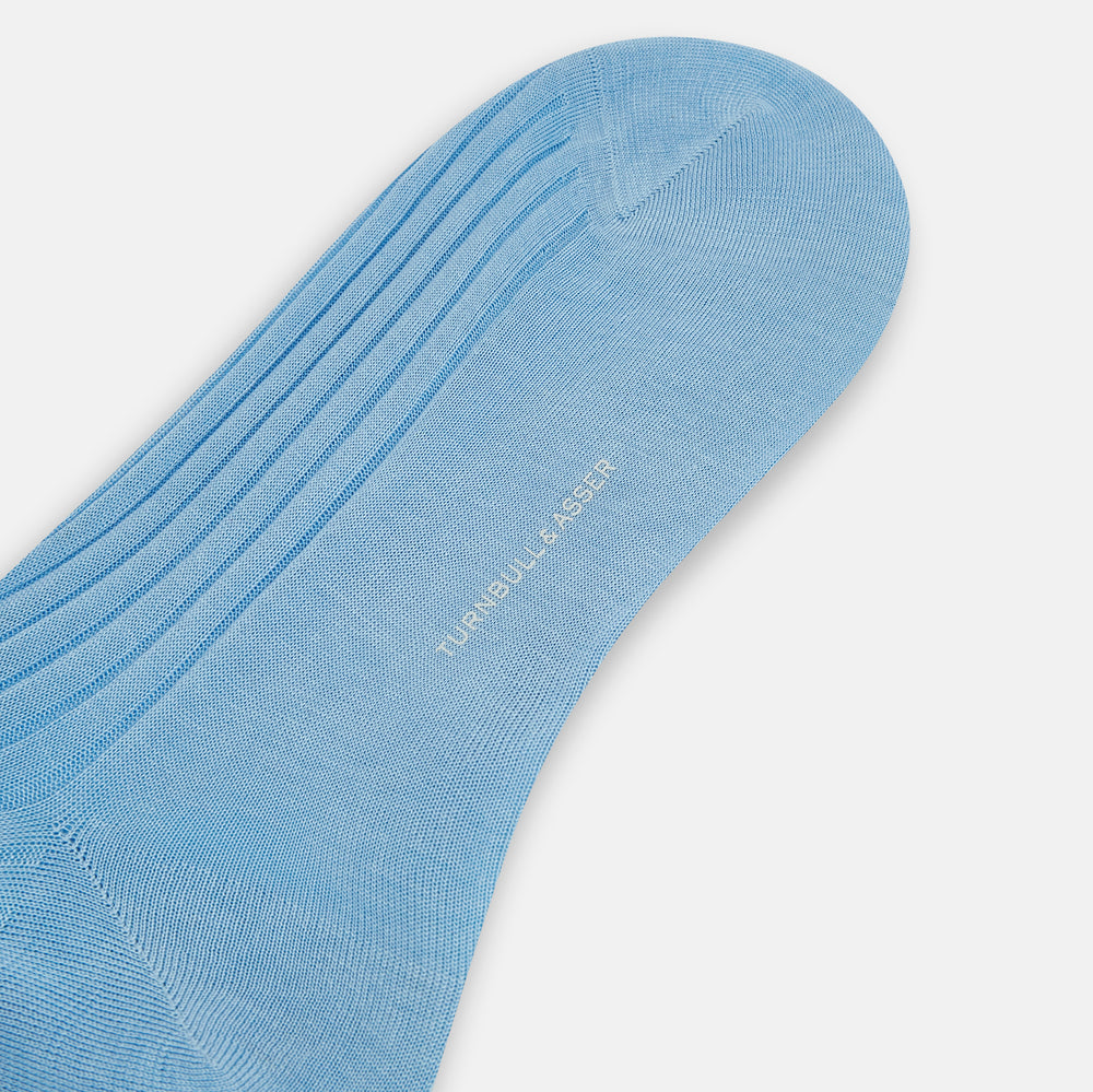 A single Turnbull & Asser Pale Blue Mid-Length Sock, made from Egyptian cotton with a ribbed texture, is displayed upright against a plain white background.