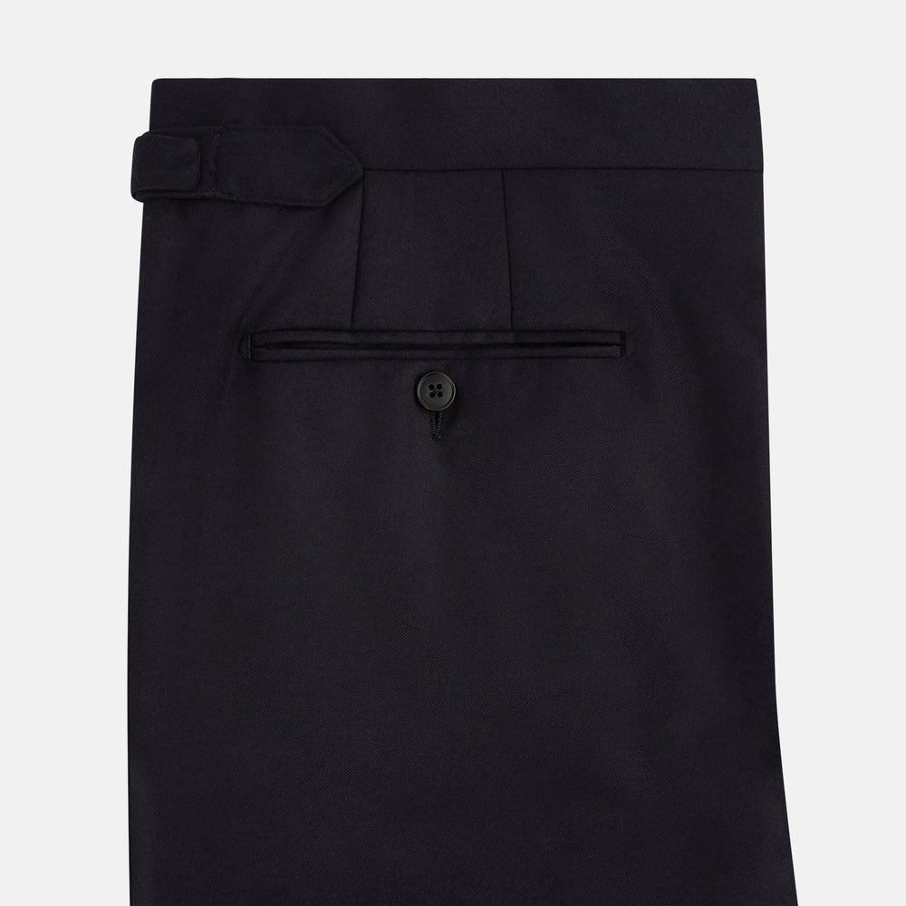 The Turnbull & Asser Short Navy Single Breasted Suit is shown flat on a white background, with a notch lapel jacket featuring two front pockets and matching trousers neatly folded underneath.