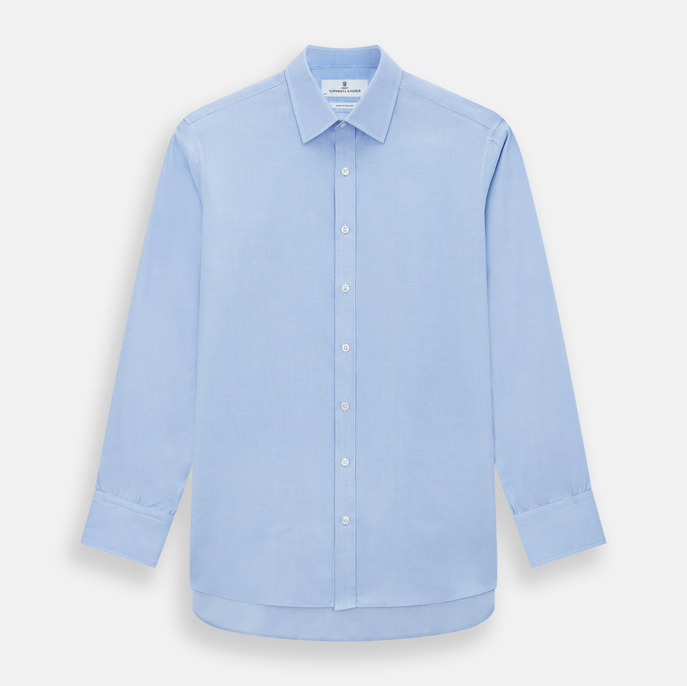 The Blue Herringbone Mayfair Shirt by Turnbull & Asser features light blue and white stripes, long sleeves, a classic collar, white buttons, and buttoned cuffs. Shown on a plain white background, it's perfect for formal occasions.