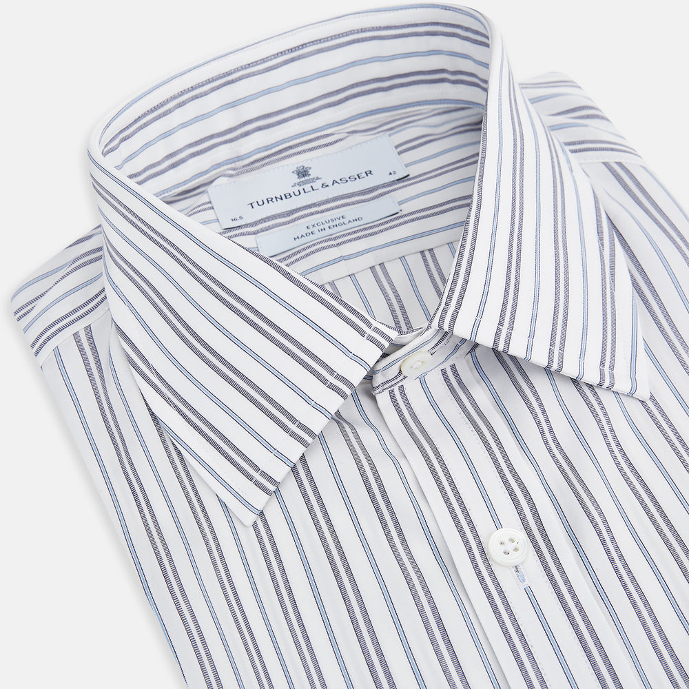 The Turnbull & Asser Navy Multi Stripe Mayfair Shirt features a T&A collar and premium Italian cotton, with vertical blue and white stripes. It is shown neatly laid flat on a white background.