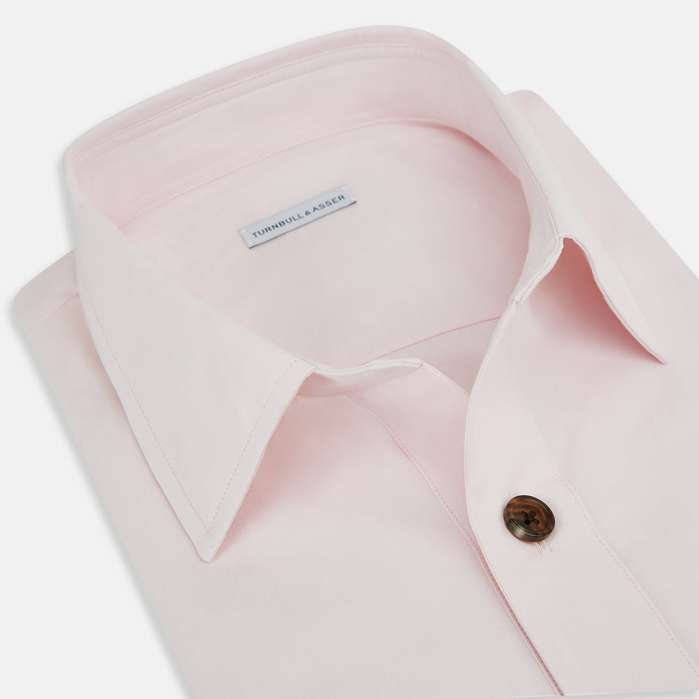 The Soft Pink Hyde Overshirt by Turnbull & Asser features long sleeves, sanforised cotton, dark buttons, and a left front pocket, shown laid flat on a white background.