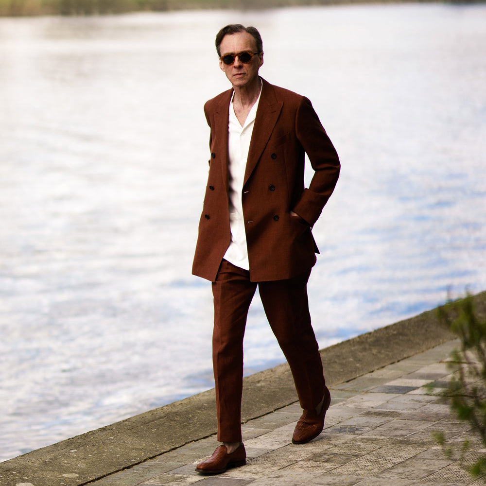 Turnbull & Asser’s Rust Linen-Wool-Silk Gerry Trousers, in a classic fit with straight legs, pleats, belt loops, and front button-zip closure, are neatly displayed flat on a white background.