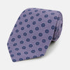 View 1 of product The Turnbull & Asser Lilac Medallion Printed Silk Tie is crafted from English silk with a geometric motif of small blue circles and a subtle checkered background.