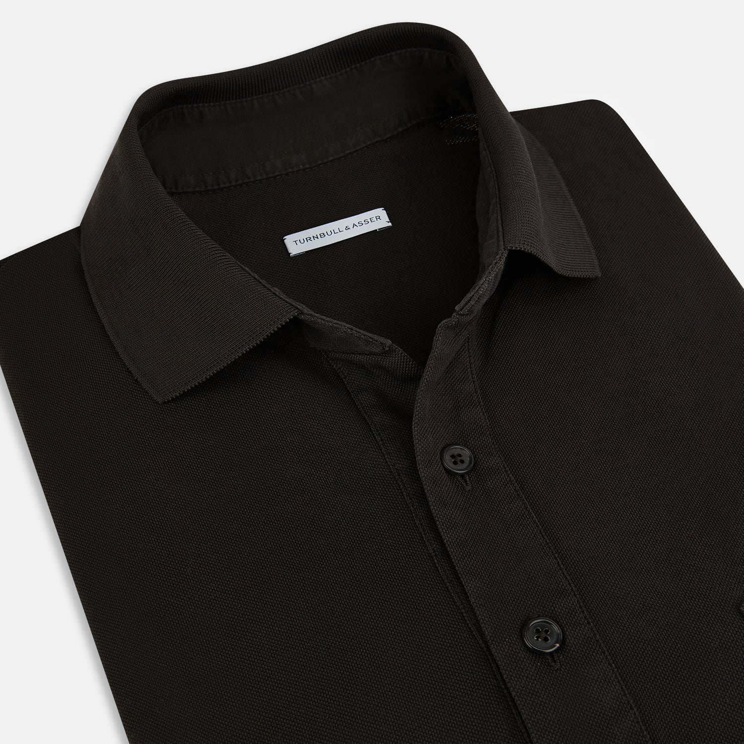 View 2 of product A brown cotton jersey polo shirt by Turnbull & Asser with short sleeves, a collar, three buttons, and a buttoned chest pocket, laid flat on a white background.