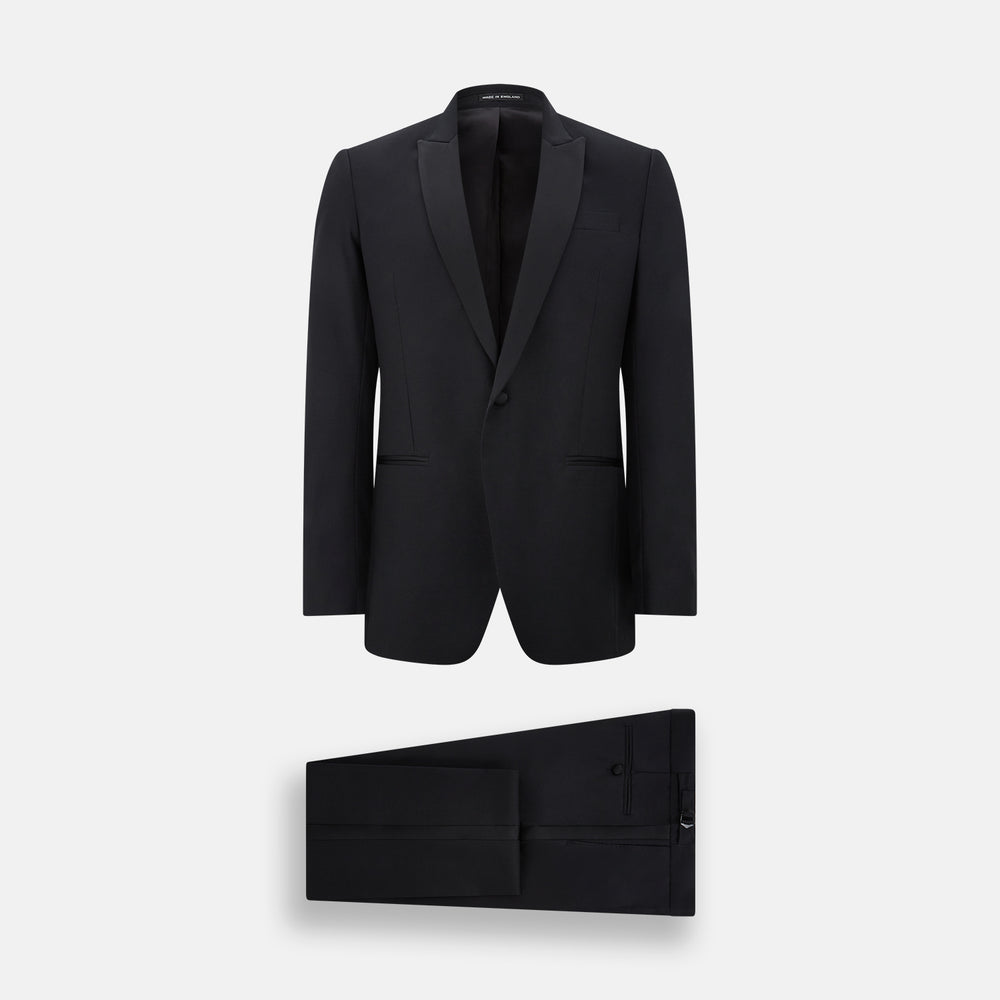 The Turnbull & Asser Black Single Breasted Dinner Suit features fine wool, a satin shawl collar jacket, and matching trousers—perfect formal wear, shown on a plain white background.