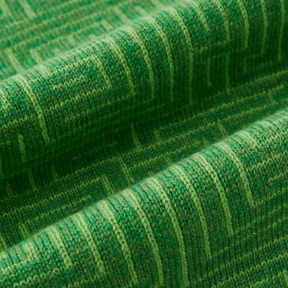 The Turnbull & Asser Kelly Green Fretwork Cashmere Knitted Scarf features a subtle, intricate pattern and is neatly knotted against a plain white background—an elegant accessory for any occasion.