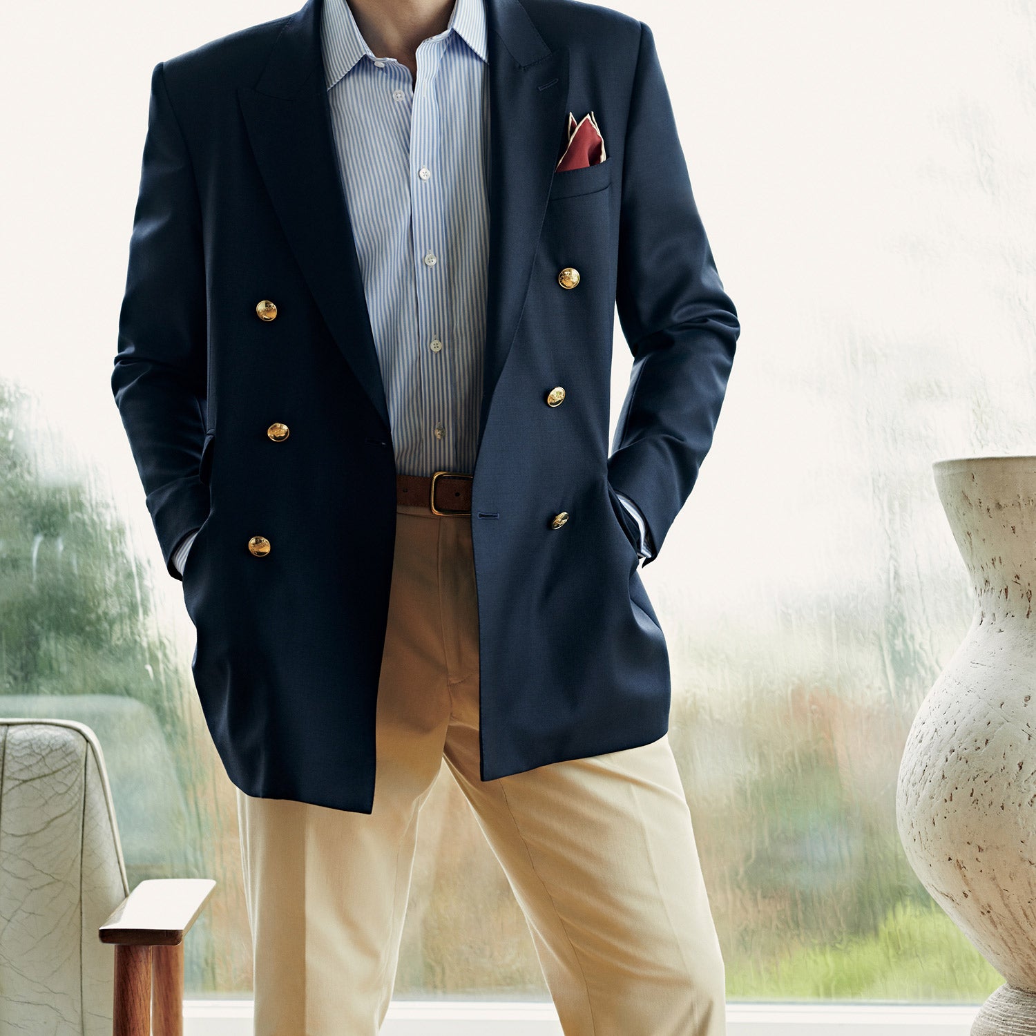 View 5 of product The Classic Navy Wool Blazer by Turnbull & Asser is a nautical double-breasted jacket with gold buttons, peaked lapels, three front pockets on one side, one on the other, and four gold buttons per cuff, shown against a white background.