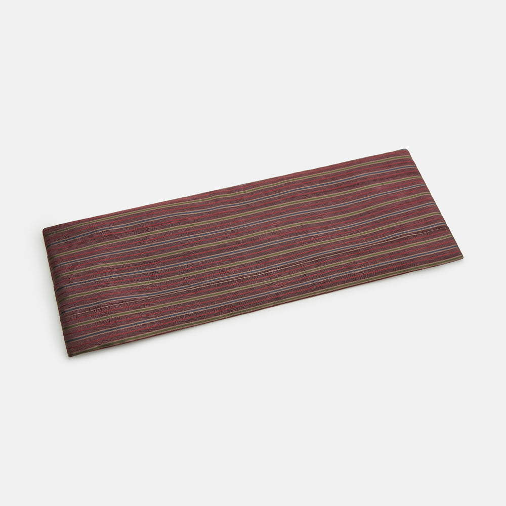 The Turnbull & Asser Claret and Green Multi Stripe Silk and Linen Cummerbund, featuring red, burgundy, green, and gold stripes reminiscent of sartorial elegance, is displayed on a plain white background.