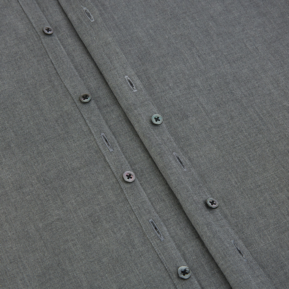 The Pale Charcoal Westminster Shirt by Turnbull & Asser features British craftsmanship with a tailored silhouette, long sleeves, pointed collar, buttoned cuffs, and a solid pale charcoal hue, elegantly shown against a white background.