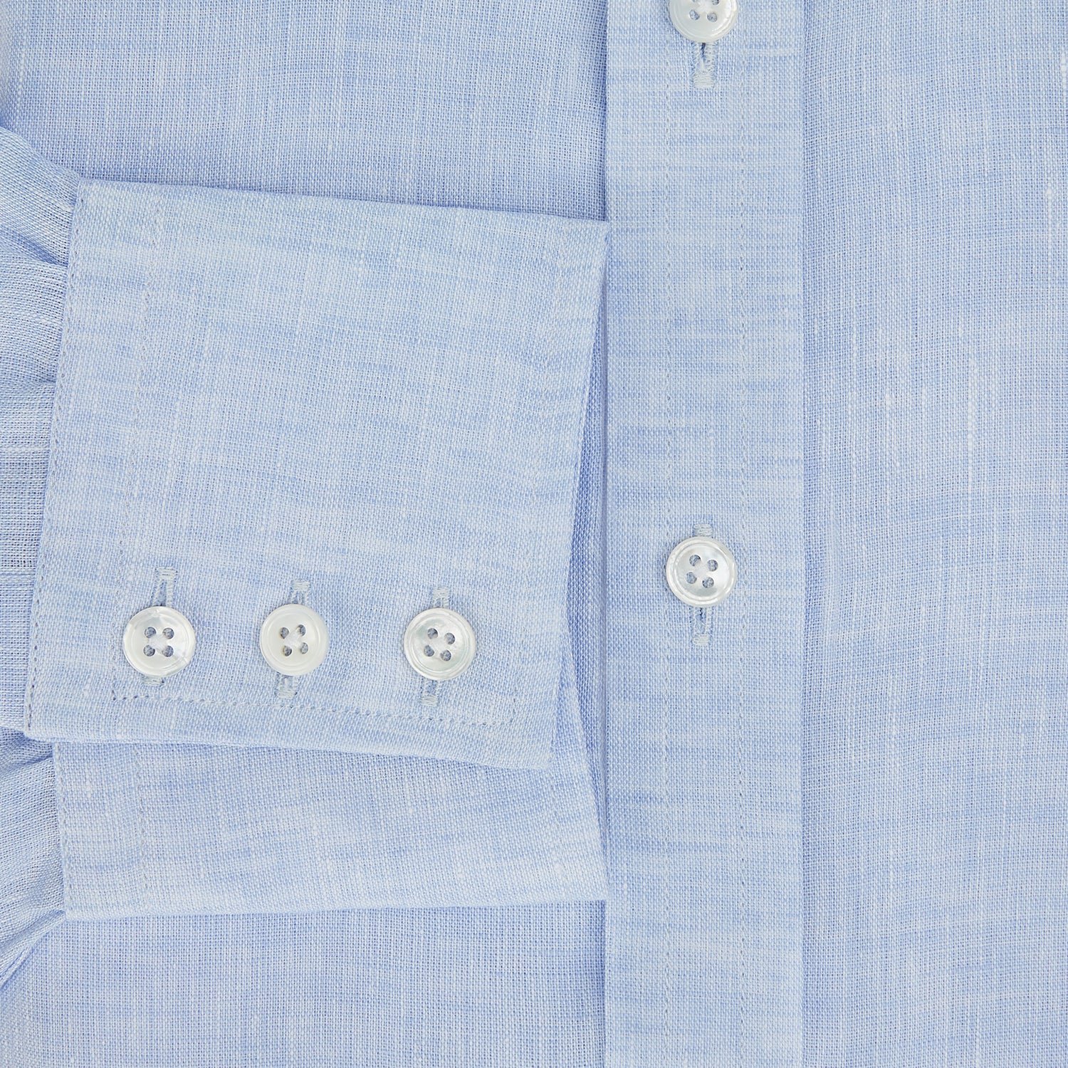 View 4 of product The Turnbull & Asser Pale Blue Linen Mayfair Shirt features a collar, front pocket, and white buttons. This long-sleeve shirt is displayed on a white background.
