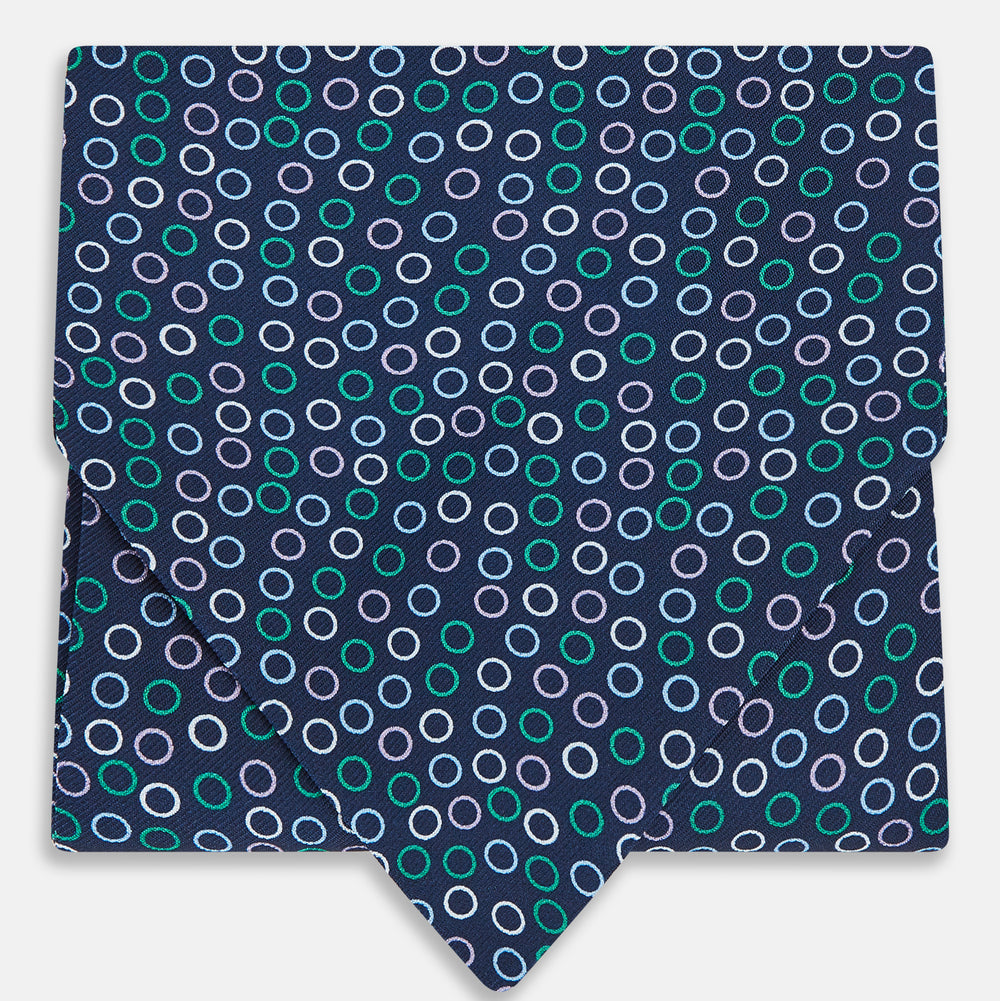 Turnbull & Asser's Multicoloured Dark Navy Circle Silk Cravat features blue, white, and green-outlined circles—ideal for weddings or pairing with classic British attire.
