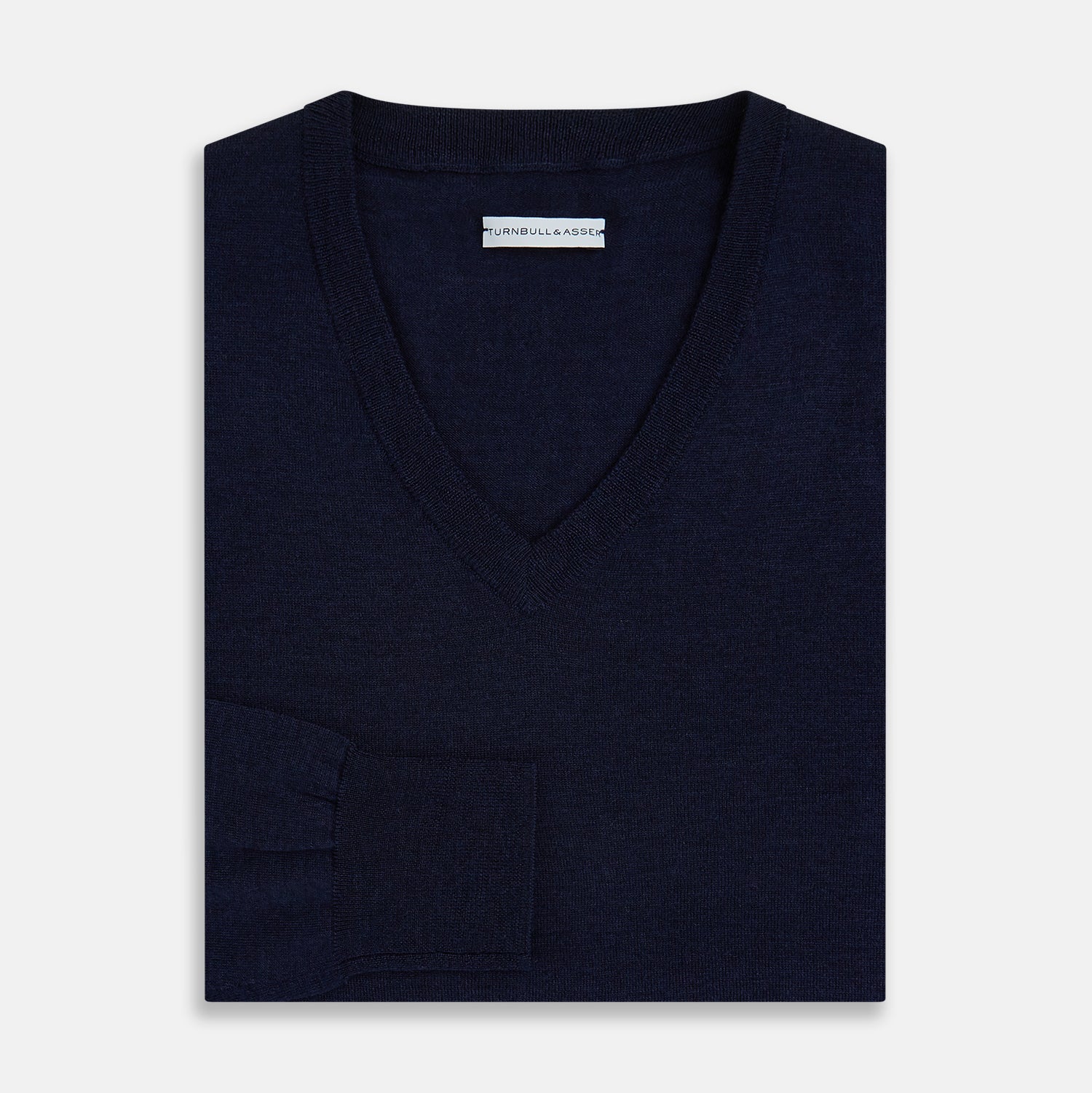 View 9 of product The Turnbull & Asser Navy Fine Merino V-Neck Jumper is displayed against a white background, featuring ribbed cuffs and hem for timeless style in a classic, plain long-sleeve design.