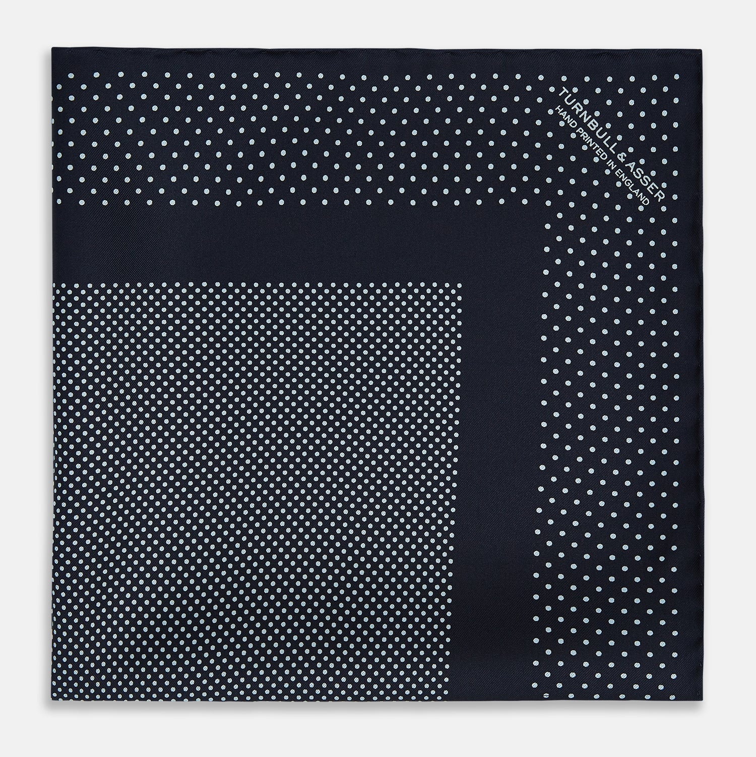 View 3 of product The Turnbull & Asser Navy and Light Blue Dot Silk Pocket Square features white polka dots, a contrasting border, and an inner square design, showcasing handmade craftsmanship with its expertly folded finish.