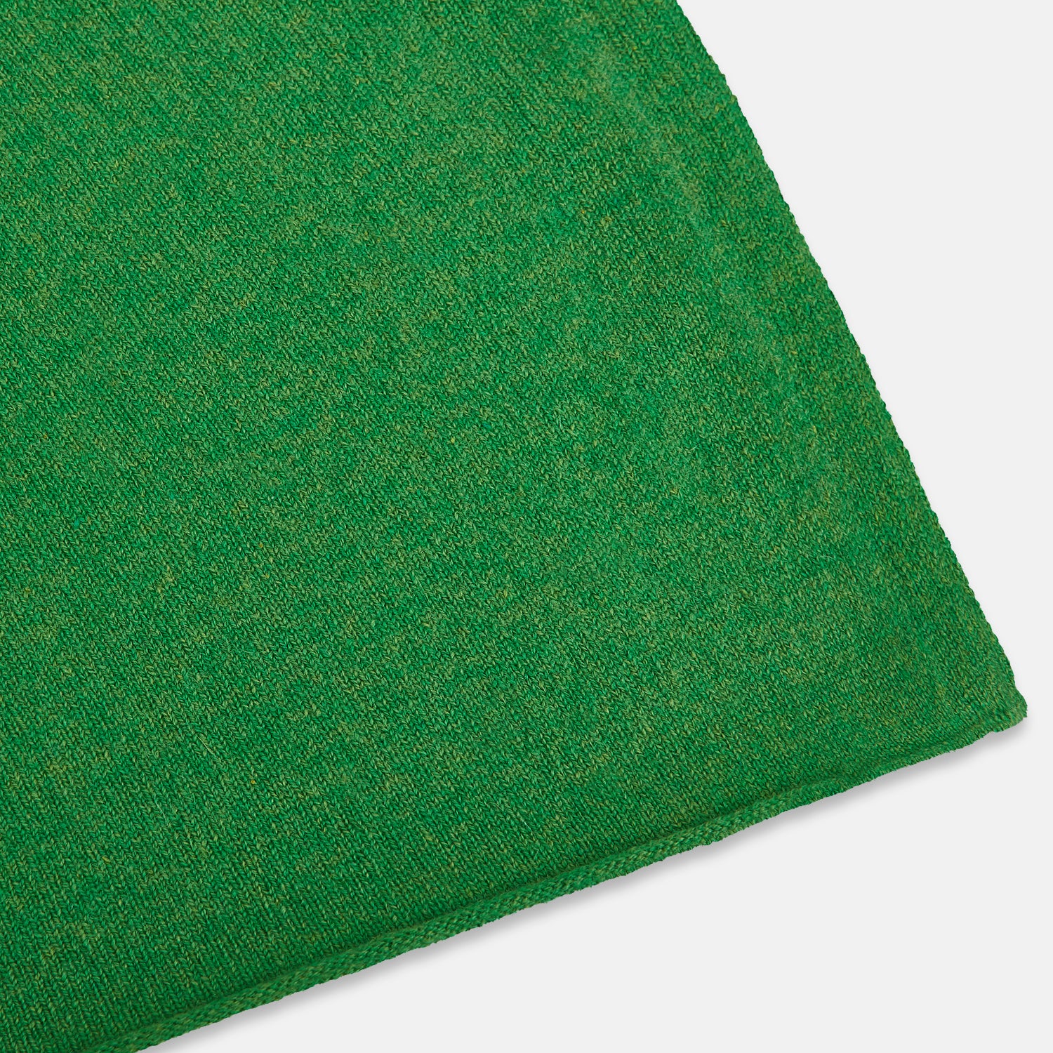 Image 2 of product The Turnbull & Asser Plain Kelly Green Cashmere Knitted Scarf is shown looped at the top with both ends hanging down, its soft texture and vibrant color standing out against a plain white background.