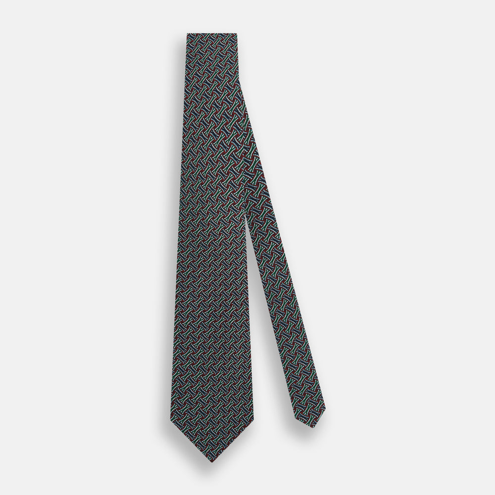 The Forest Green and Red Weave-Patterned Printed Silk Tie by Turnbull & Asser features an intricate geometric motif in red, green, blue, and white, crafted from luxurious English silk for classic sophistication.