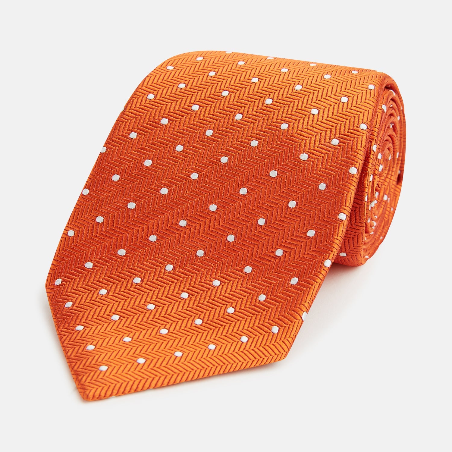 View 1 of product The Turnbull & Asser Orange and White Micro Dot Silk Tie features a subtle herringbone weave with small white dots—an elegant, modern accessory for the office.