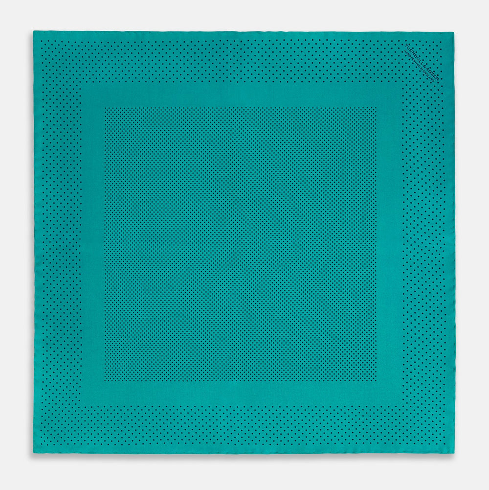 The Turnbull & Asser Petrol Green Dot Silk Pocket Square, made in England, features a border and small black polka dots, neatly folded to showcase both front and back sides.