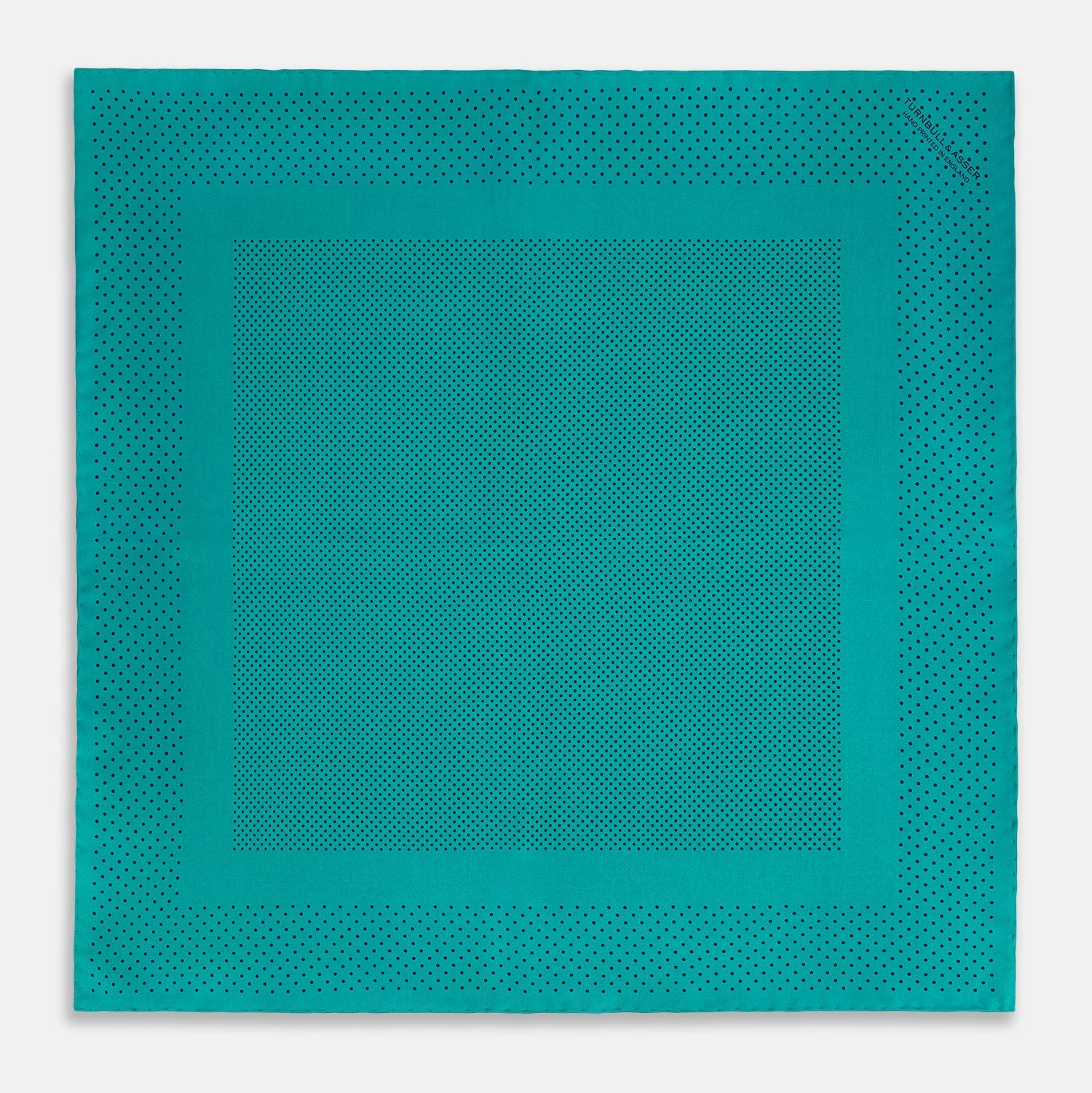 View 4 of product The Turnbull & Asser Petrol Green Dot Silk Pocket Square, made in England, features a border and small black polka dots, neatly folded to showcase both front and back sides.