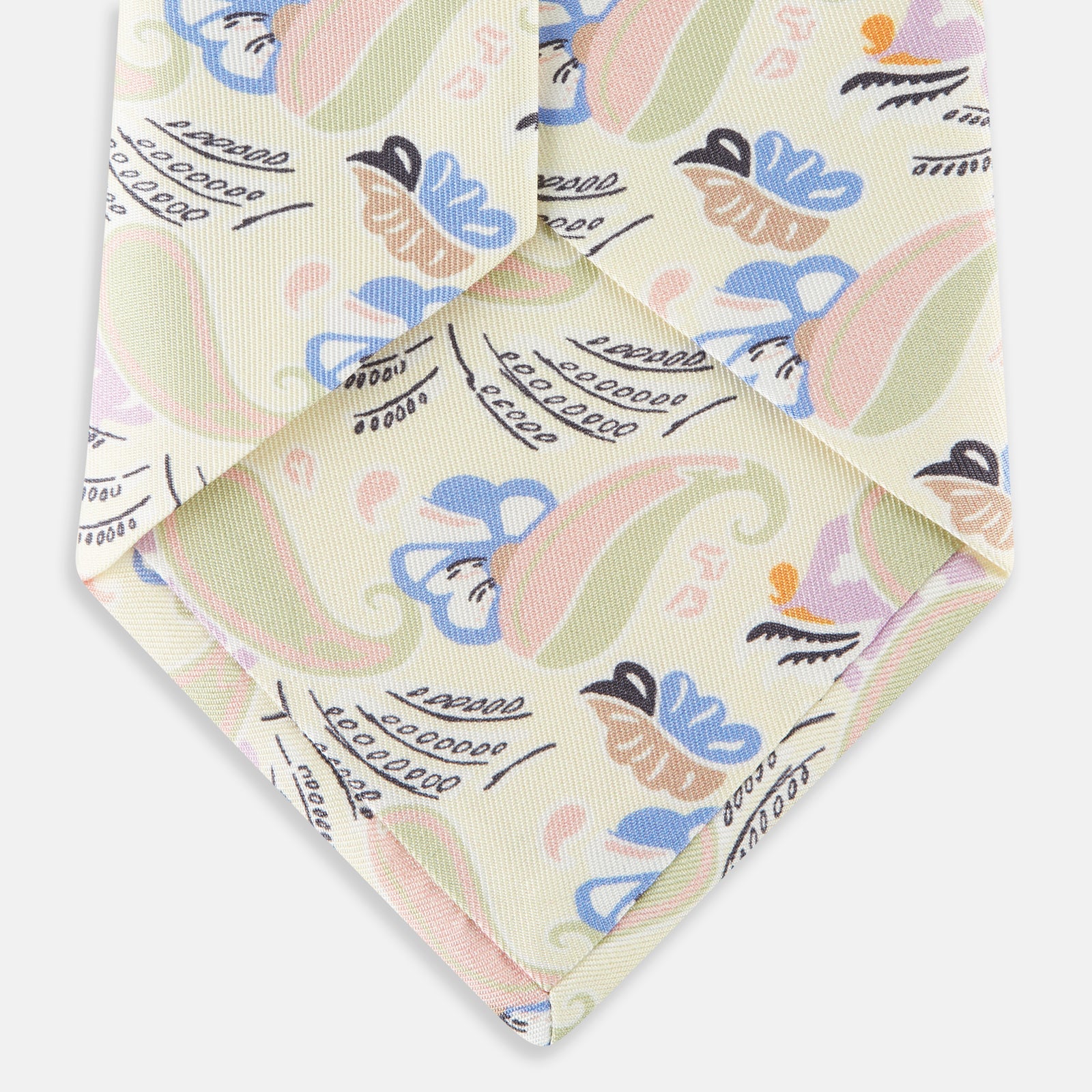 View 4 of product A rolled-up Cream Multi Bloomsbury-Inspired Pattern Silk Tie by Turnbull & Asser, featuring a pastel floral and paisley design in green, blue, pink, and orange tones, displayed on a white background.