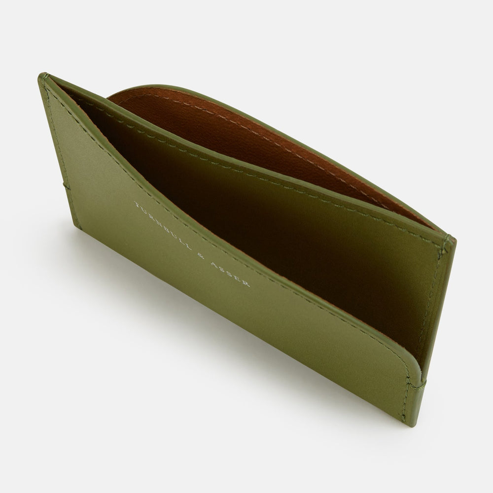 The Moss Green Slim Rounded Card Holder by Turnbull & Asser features Italian leather, white printed branding on the front, detailed stitching, and a curved seam at the upper right corner.