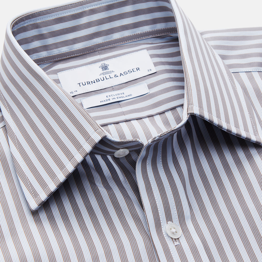 The Turnbull & Asser Pale Blue Multi Stripe Cotton Regular Fit Mayfair Shirt features long sleeves, a pointed collar, buttoned cuffs, and vertical stripes in pale blue tones, displayed against a white background.