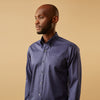 View 2 of product The Blue Piece Dyed Weekend Fit Suffolk Shirt by Turnbull & Asser features a button-down Dorset collar, chest pocket, white buttons, and long sleeves in classic navy, laid flat against a white background.