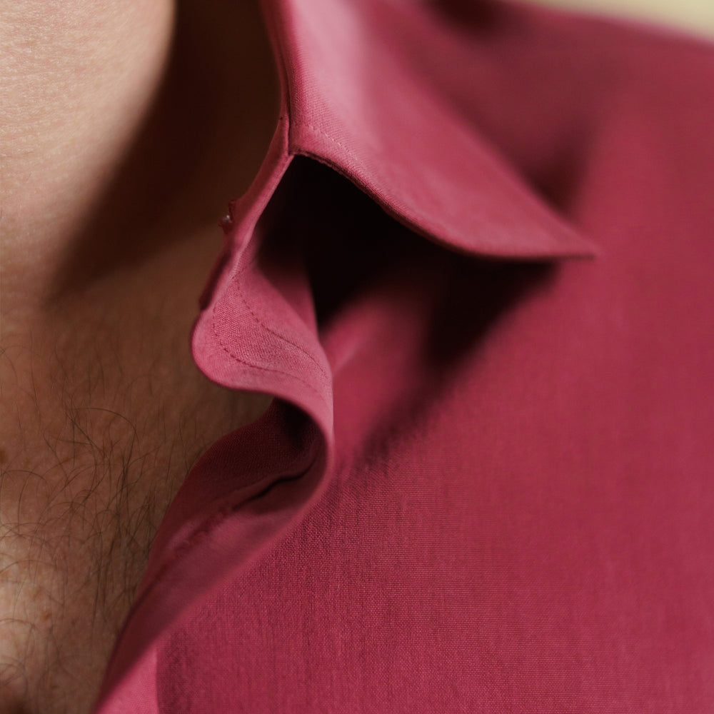 The Turnbull & Asser Burgundy Silk Shirt features a T&A collar and 3-button cuffs, offering a refined alternative to a black tie for modern style. Displayed folded on a white background.