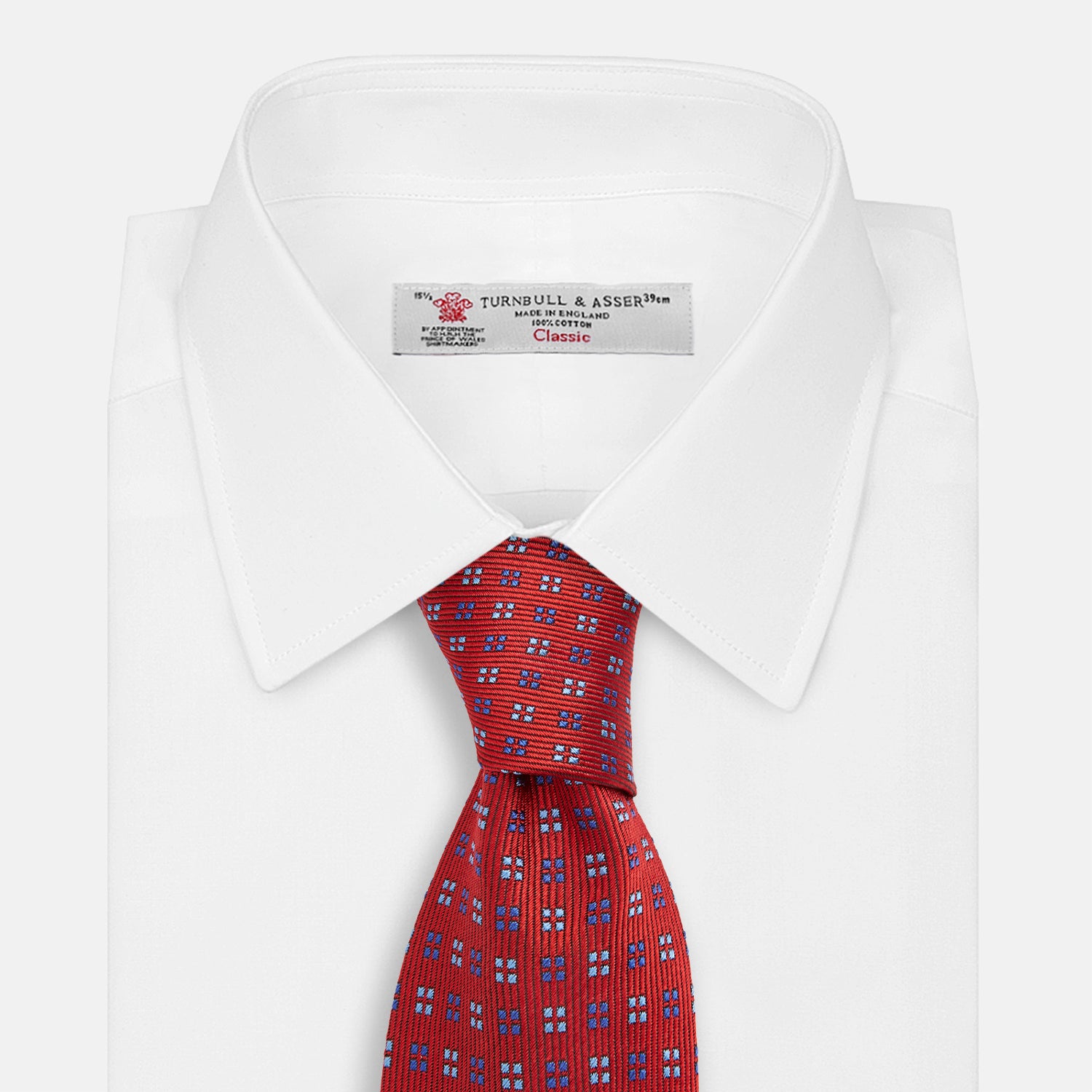 View 2 of product The Turnbull & Asser MINI SQUARE SPOT TULIP RED BLUE TIE features a vivid red base with blue and white geometric spots, making it a stylish addition to any refined ensemble.