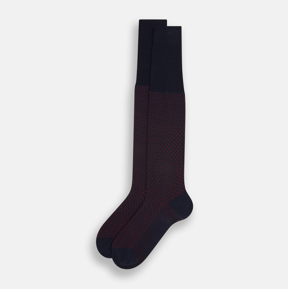 The Turnbull & Asser Navy/Red Motif Long Sock is crafted from mercerised Egyptian cotton, featuring a subtle red and navy diamond pattern with a solid navy cuff, heel, and toe, displayed on a white background.