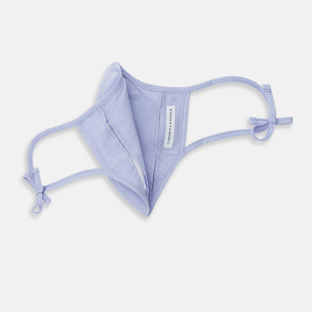 The Turnbull & Asser Plain Pale Blue Commuter Mask with 3 Viroformula™ filters features adjustable ear loops and side ties—ideal for daily use, shown against a white background.