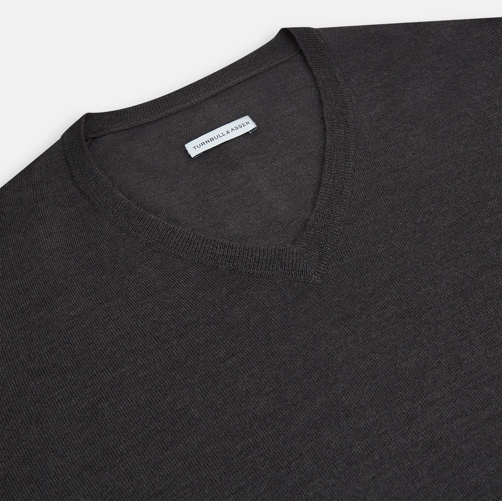 The Turnbull & Asser Charcoal Grey Merino V Neck Jumper is a classic long-sleeve knit with ribbed cuffs and hem, featured in our knitwear collection and shown against a white background.