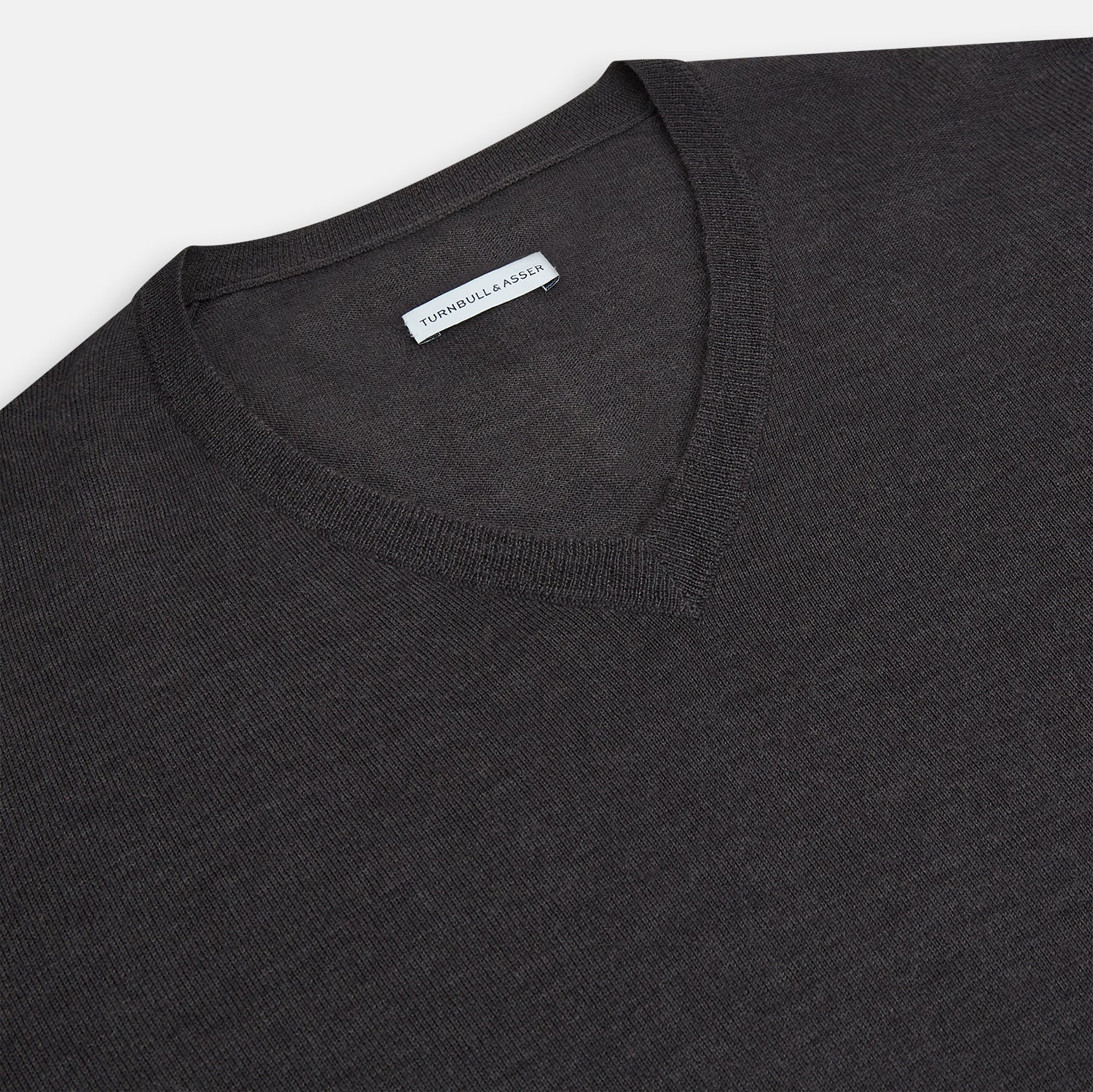 View 2 of product The Turnbull & Asser Charcoal Grey Merino V Neck Jumper is a classic long-sleeve knit with ribbed cuffs and hem, featured in our knitwear collection and shown against a white background.