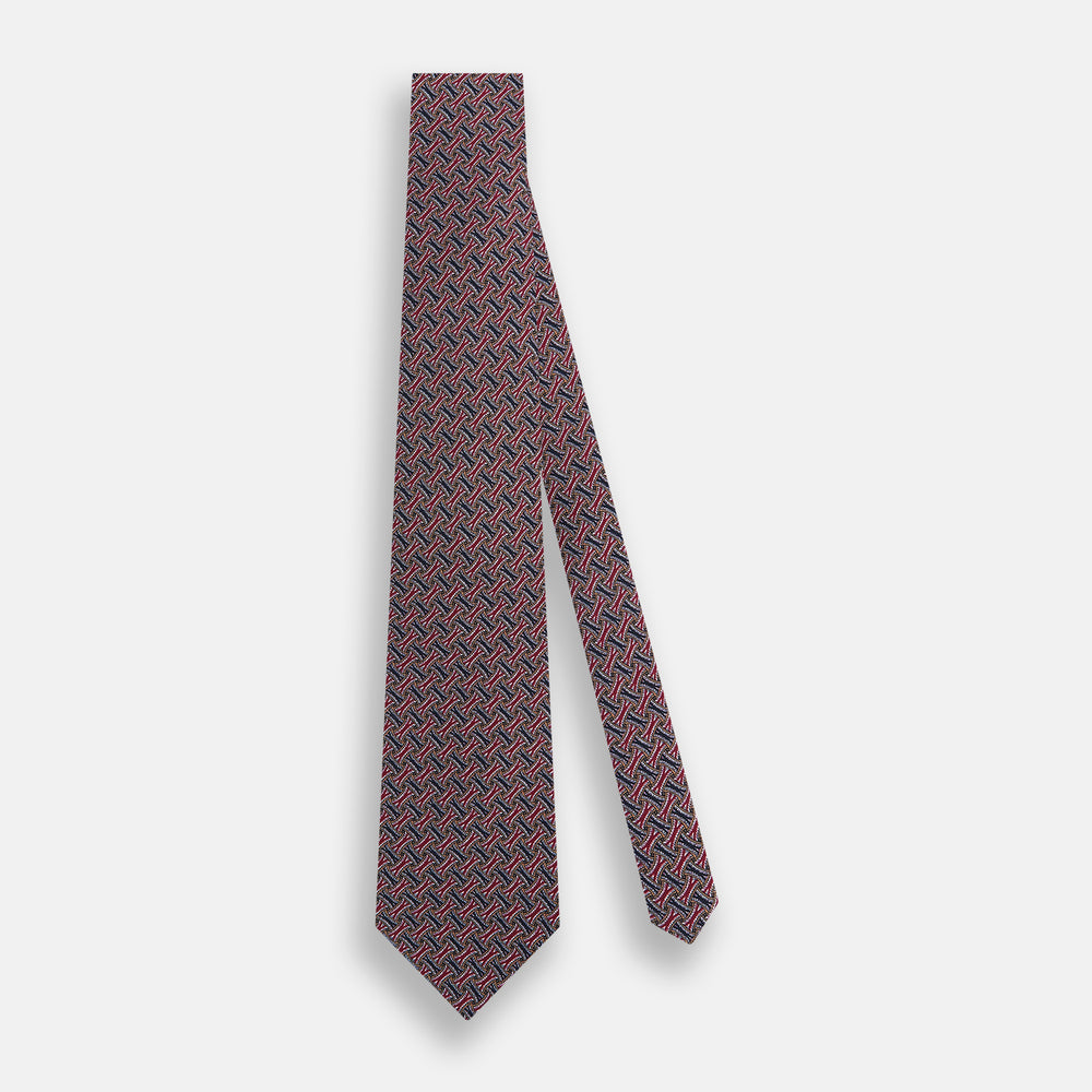 The Turnbull & Asser Burgundy and Navy Weave-Patterned Printed Silk Tie features an intricate geometric design, shown rolled on a plain white background.