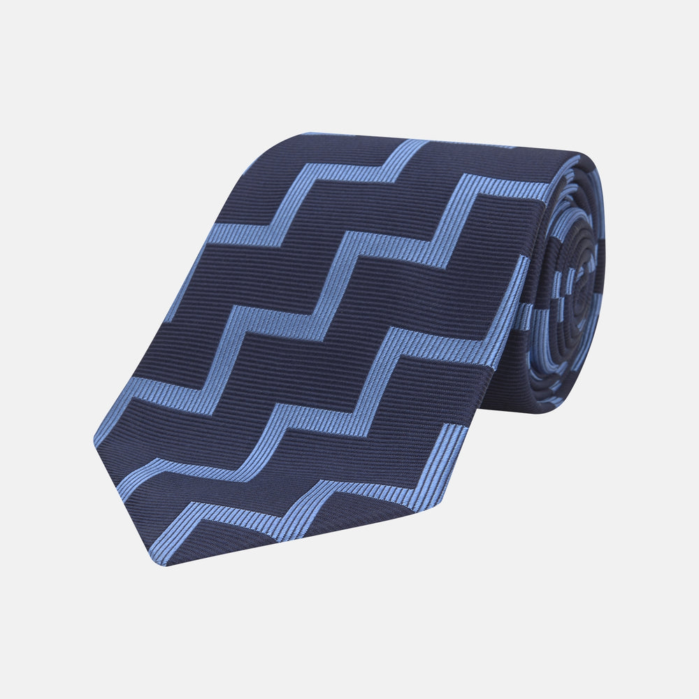 The Turnbull & Asser Navy and Light Blue Striped Zigzag Silk Tie features a striking zigzag pattern—a stylish accessory for the modern gentleman.
