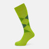 View 1 of product The Lime Check Mid-Length Sock by Turnbull & Asser features a green and yellow argyle pattern with a ribbed cuff, crafted from comfortable cotton material, and is shown on a plain light background.