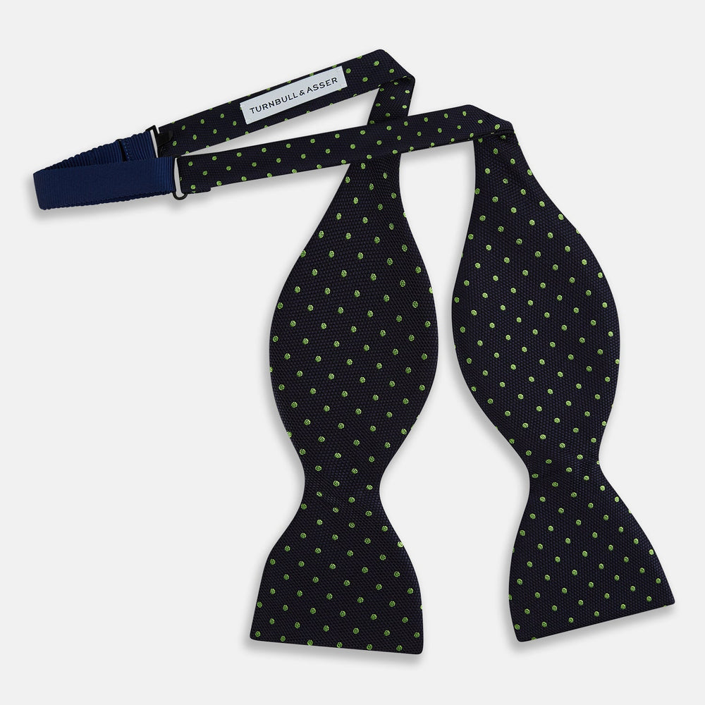The Turnbull & Asser Lime Green and Navy Micro Dot Silk Bow Tie features small lime green dots on navy silk, displayed against a plain white background.
